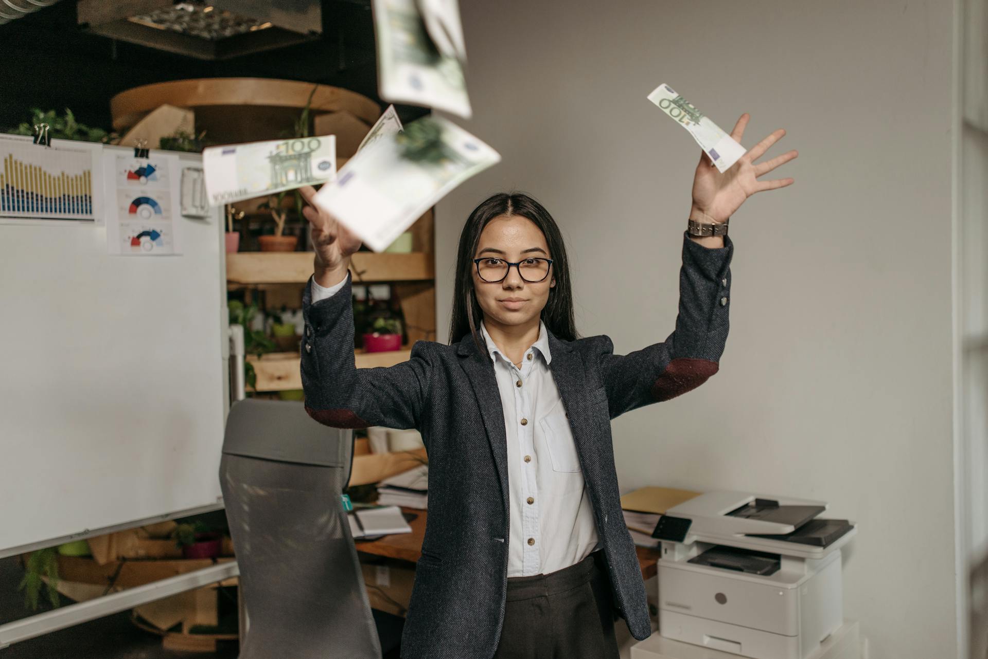 A Woman Wearing Business Attire Throwing Money in the Office