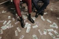 Person Sitting on the Chair with Cash on the Concrete Floor