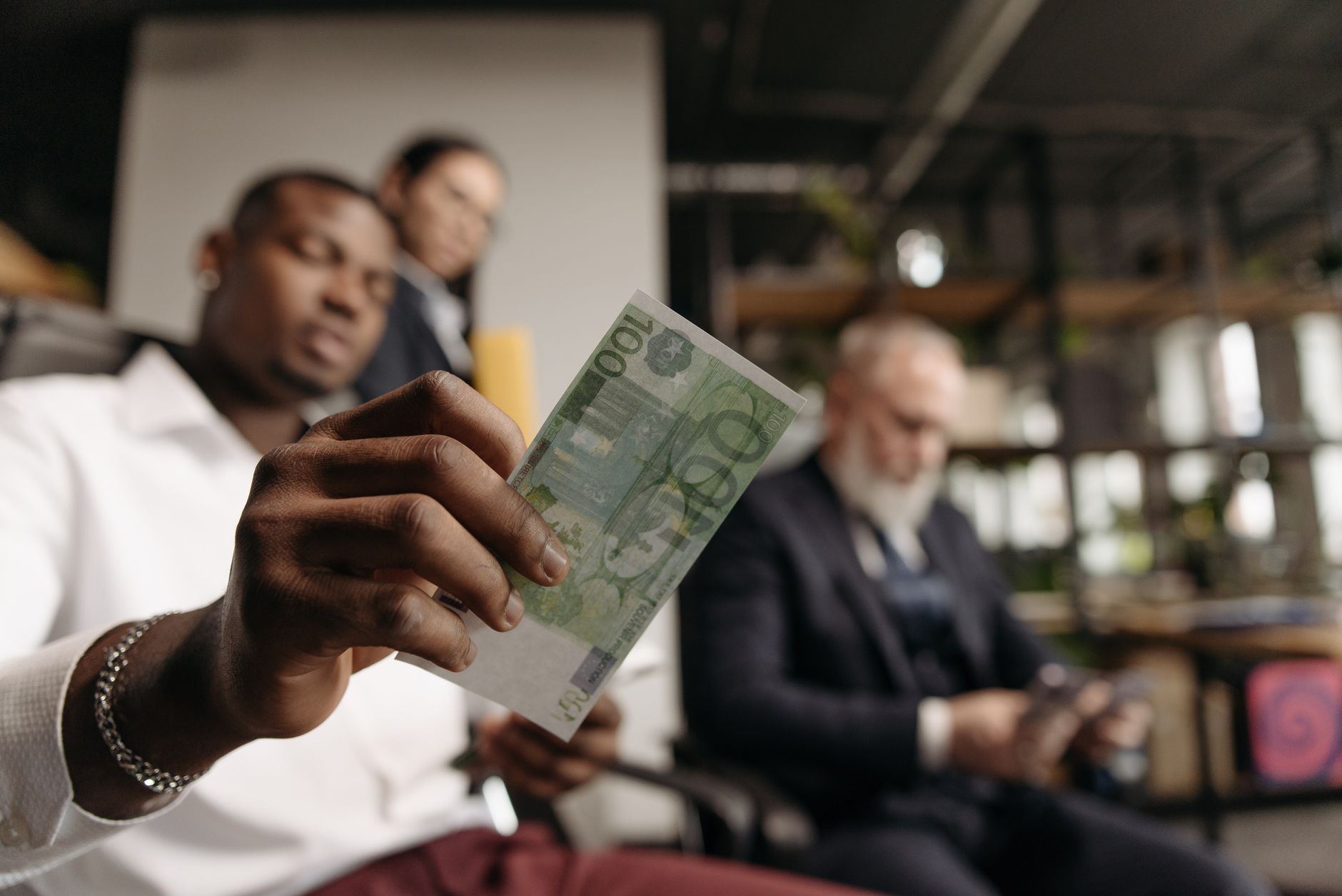 Almanya'daki farklı iş kollarını, ekonomik sektörleri ve maaş dağılımını temsil eden Euro banknotları ve profesyonel çalışan figürleri.