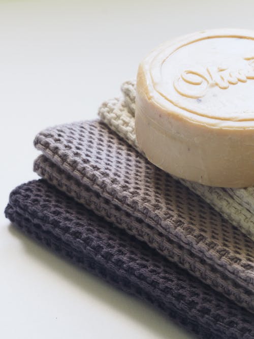 High angle of homemade natural soap placed on top of towels at soft light indoors