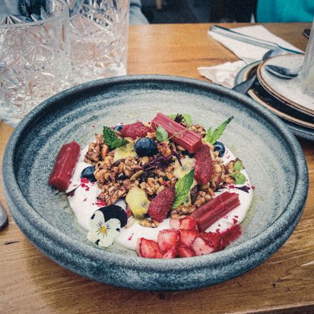 Granola with yoghurt, berries and mint in a stone bowl — Pascal Borener on Pexels