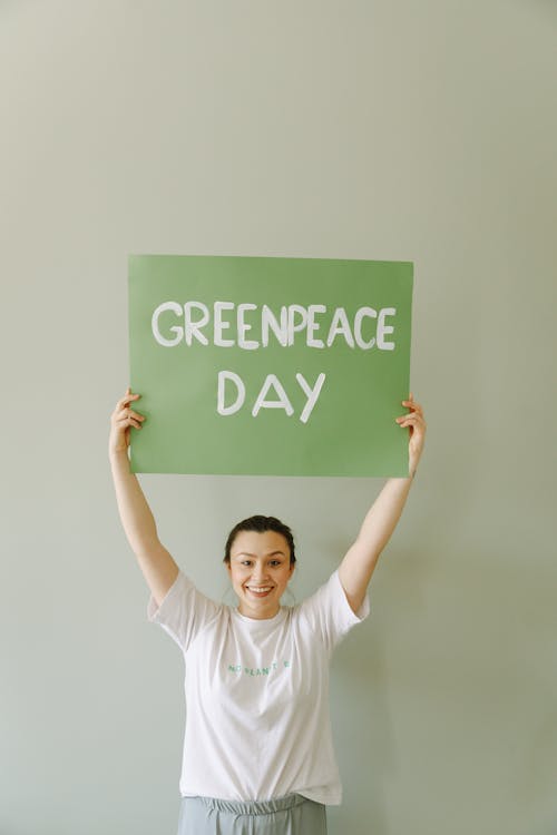 A Woman Holding a Green Banner with Message