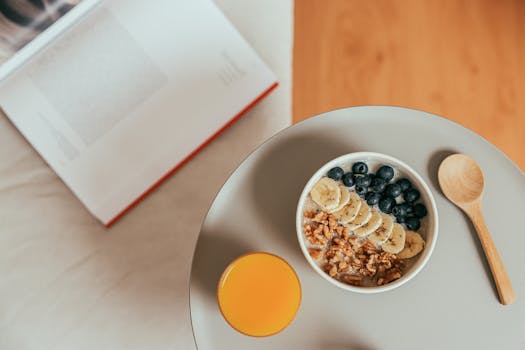 Top view of healthy breakfast with oatmeal, fresh fruit, and orange juice on a tray.