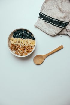 A nutritious breakfast bowl featuring bananas, blueberries, and walnuts displayed in a flatlay style.