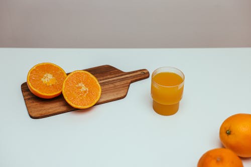 Orange Juice Beside Wooden Board
