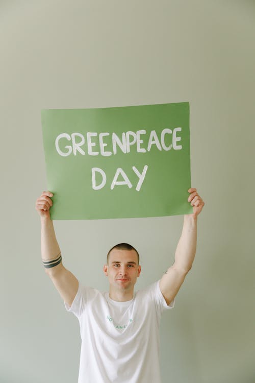 Free Man Holding a Green Peace Day Slogan Stock Photo