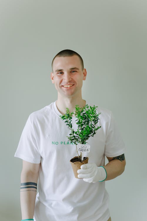 Free Photo of a Man Holding a Plant in a Pot while Smiling Stock Photo