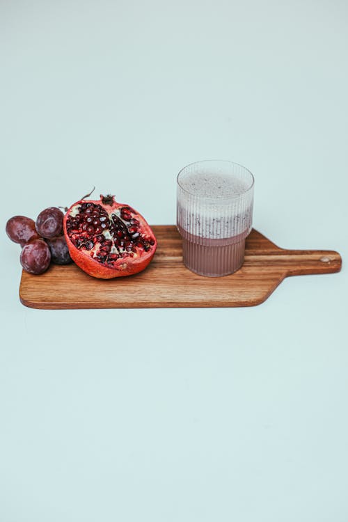 Photo of a Pomegranate Beside a Smoothie