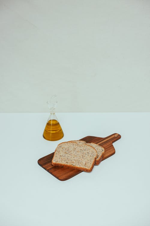 ahşap kesme tahtası, Beyaz arka plan, buğday ekmeği içeren Ücretsiz stok fotoğraf