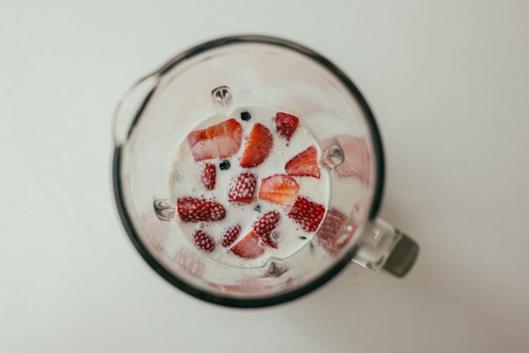 Slices Of Strawberries And Milk In A Pitcher