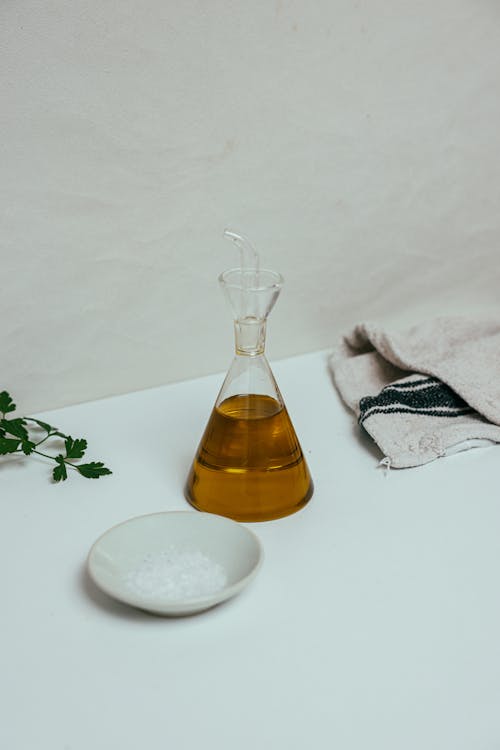 Bottle of Olive Oil Beside a White Saucer