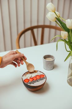 Top view of a smoothie bowl with strawberries, almonds, and chia seeds, offering a healthy breakfast option.