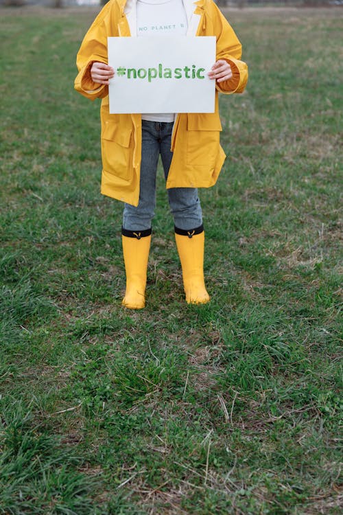 Free Person in Yellow Coat Holding a Slogan  Stock Photo