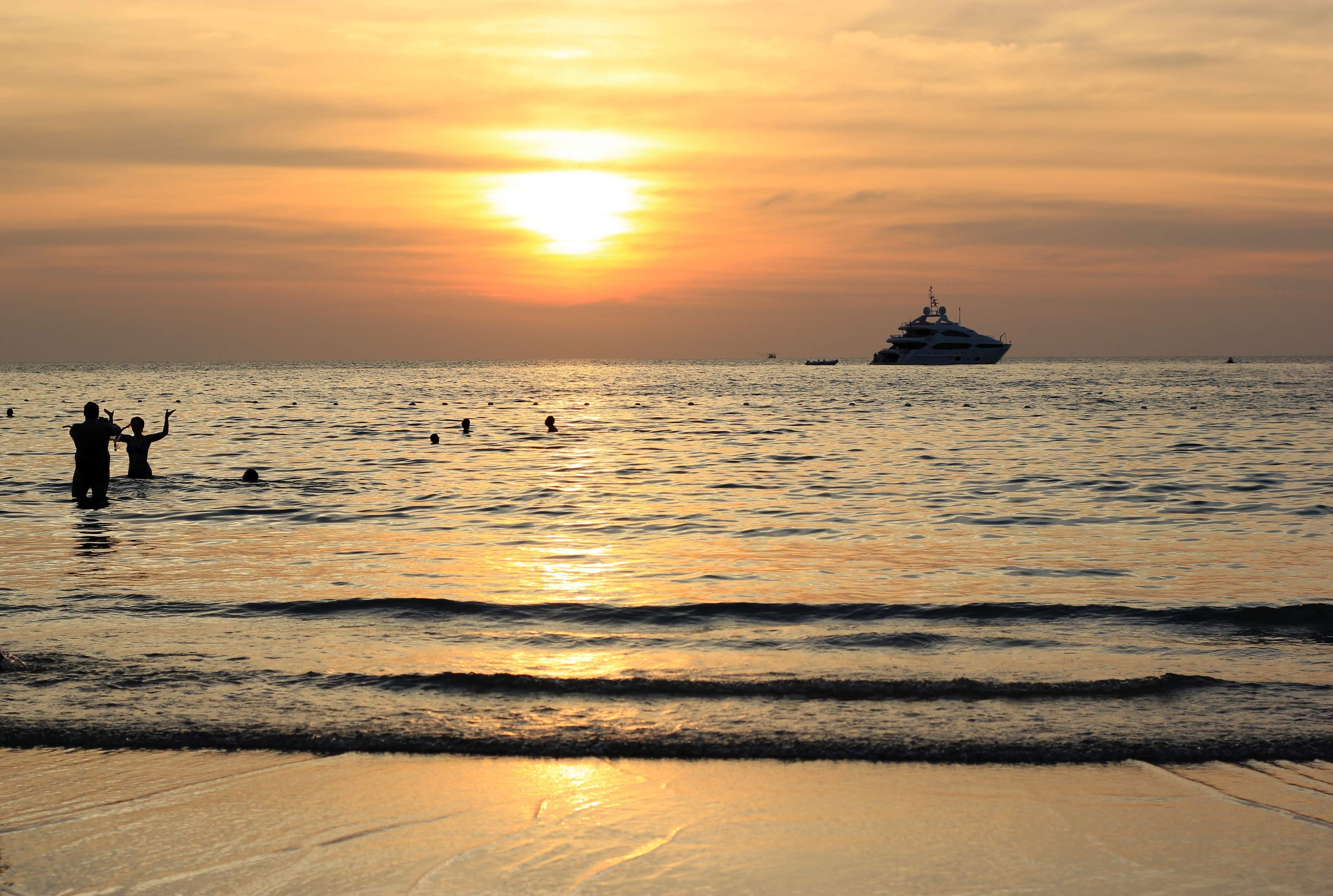 Silhouettes of People Swimming in Sea at Sunset · Free Stock Photo