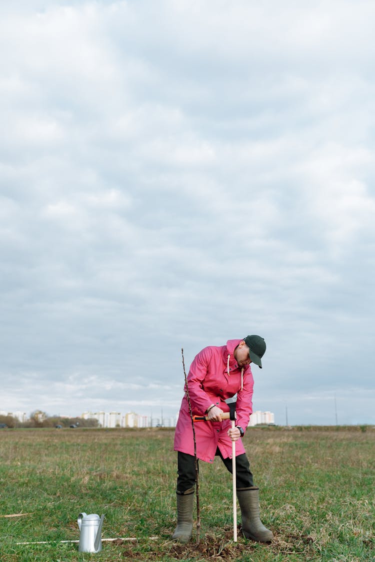 A Person In Pink Jacket Working On The Grass Field