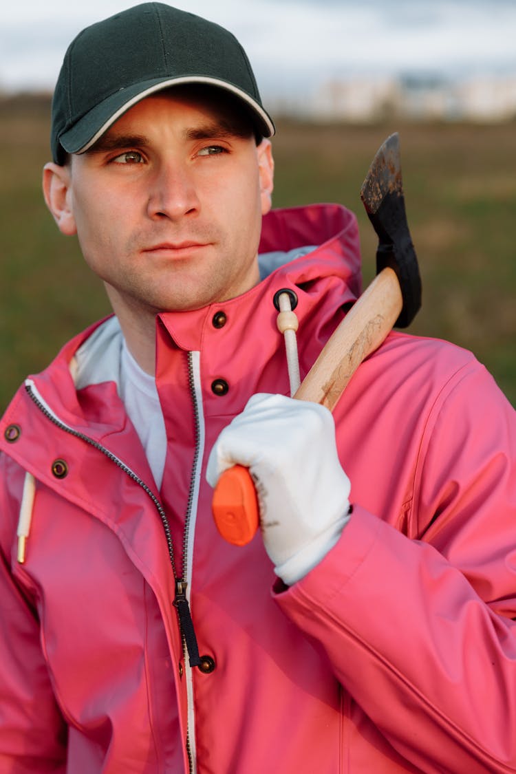 A Man In Pink Jacket Holding An Axe