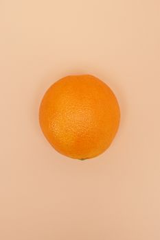 Bright orange fruit against a soft peach background, top-down view.