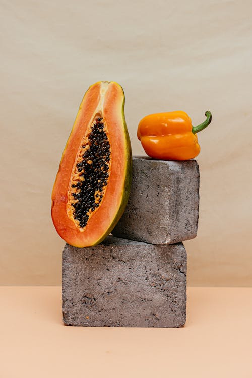 Sliced Papaya and a Bell Pepper on Concrete Blocks