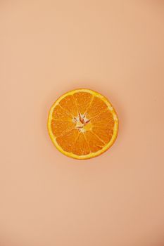 Freshly sliced orange on a beige background, highlighting its vibrant colors and textures.