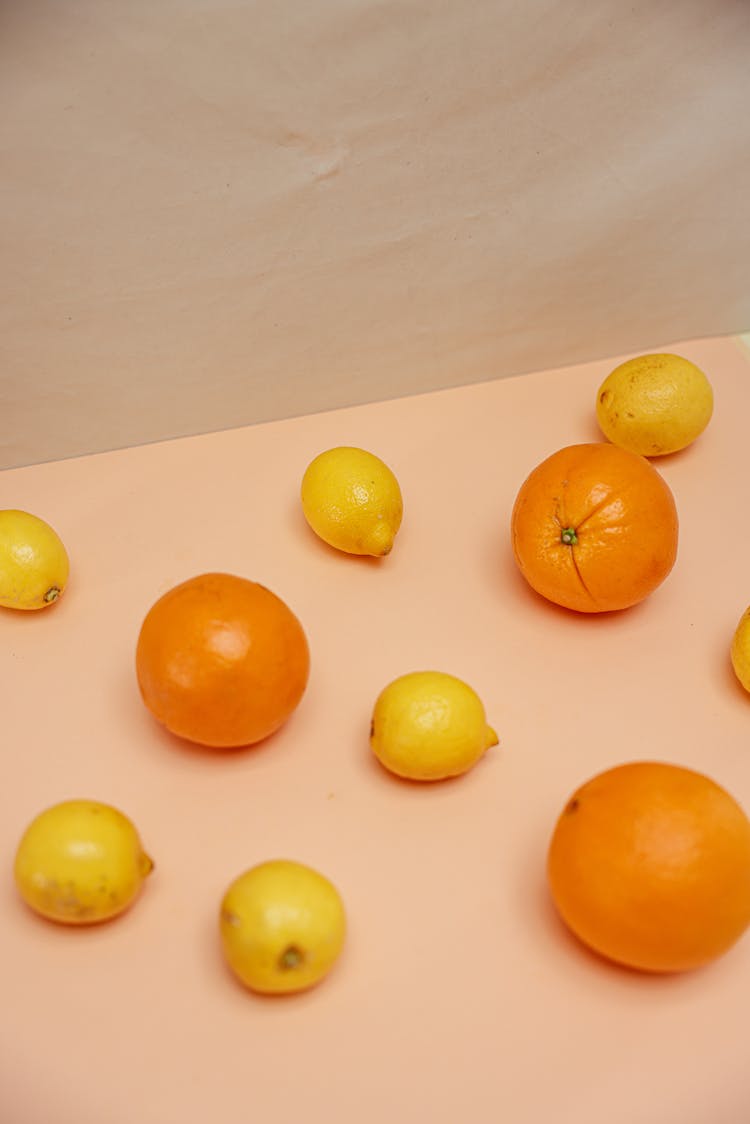 Oranges And Lemons Laid On Pink Surface