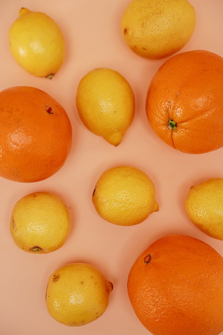 Lemons And Oranges Laid On Pink Surface