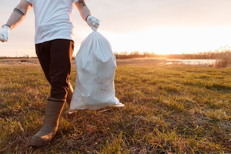 Volunteer hauling a collected bag at a community cleanup