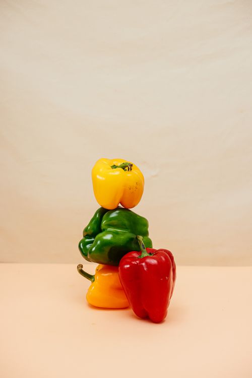 Free A stack of yellow, green, and red bell peppers in a minimalist setup, ideal for healthy living concepts. Stock Photo