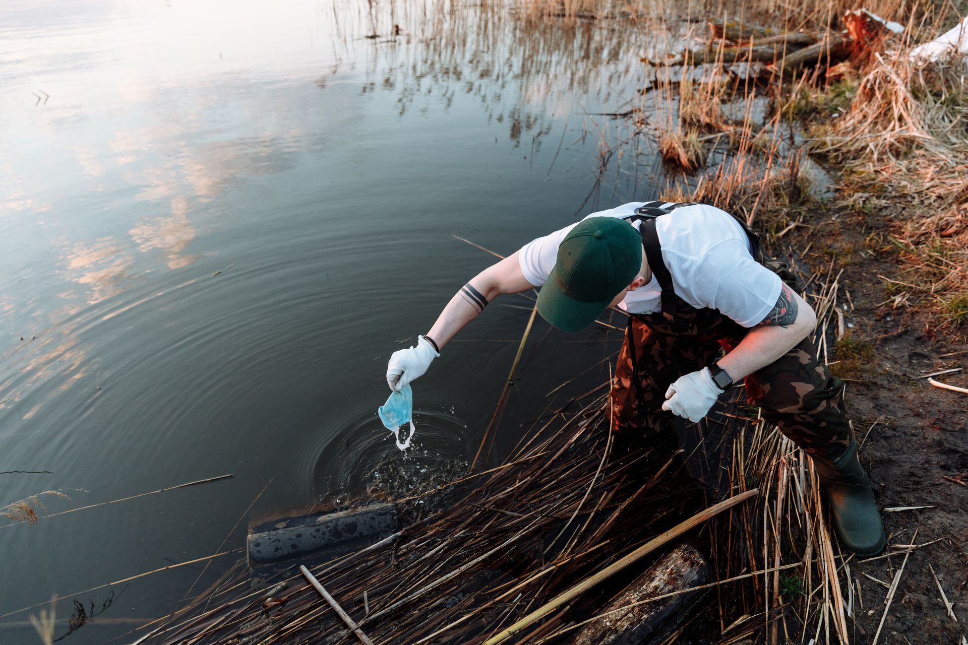 A Man Picking Up Garbage from a Lake