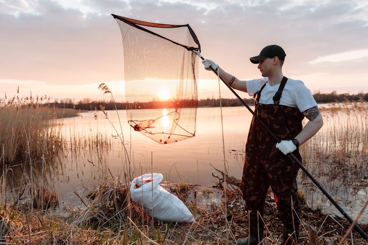 A Man Collecting Garbage In The River