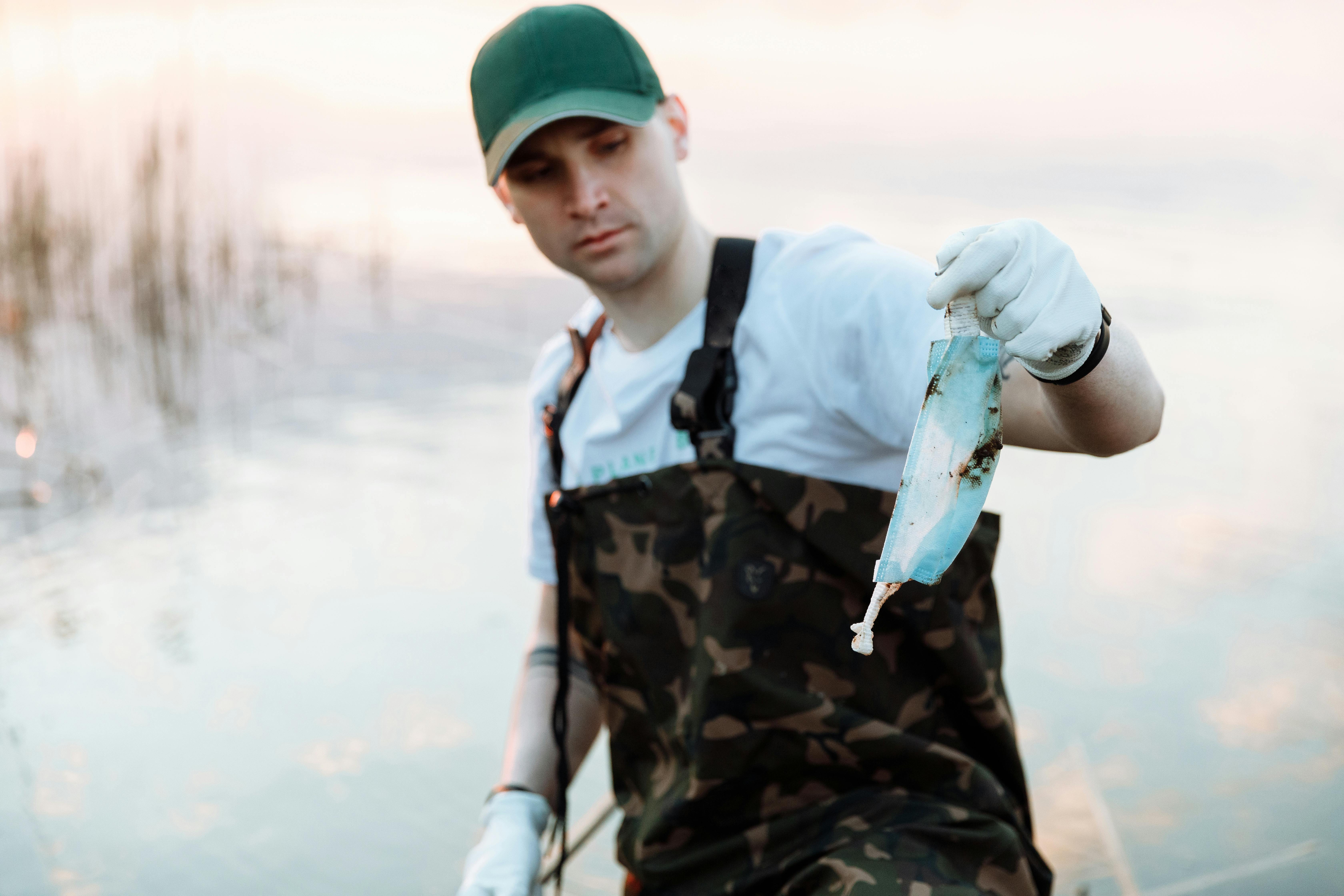 a man holding used face masks from the river