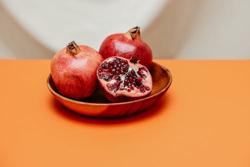 Red Round Fruit on Brown Ceramic Bowl