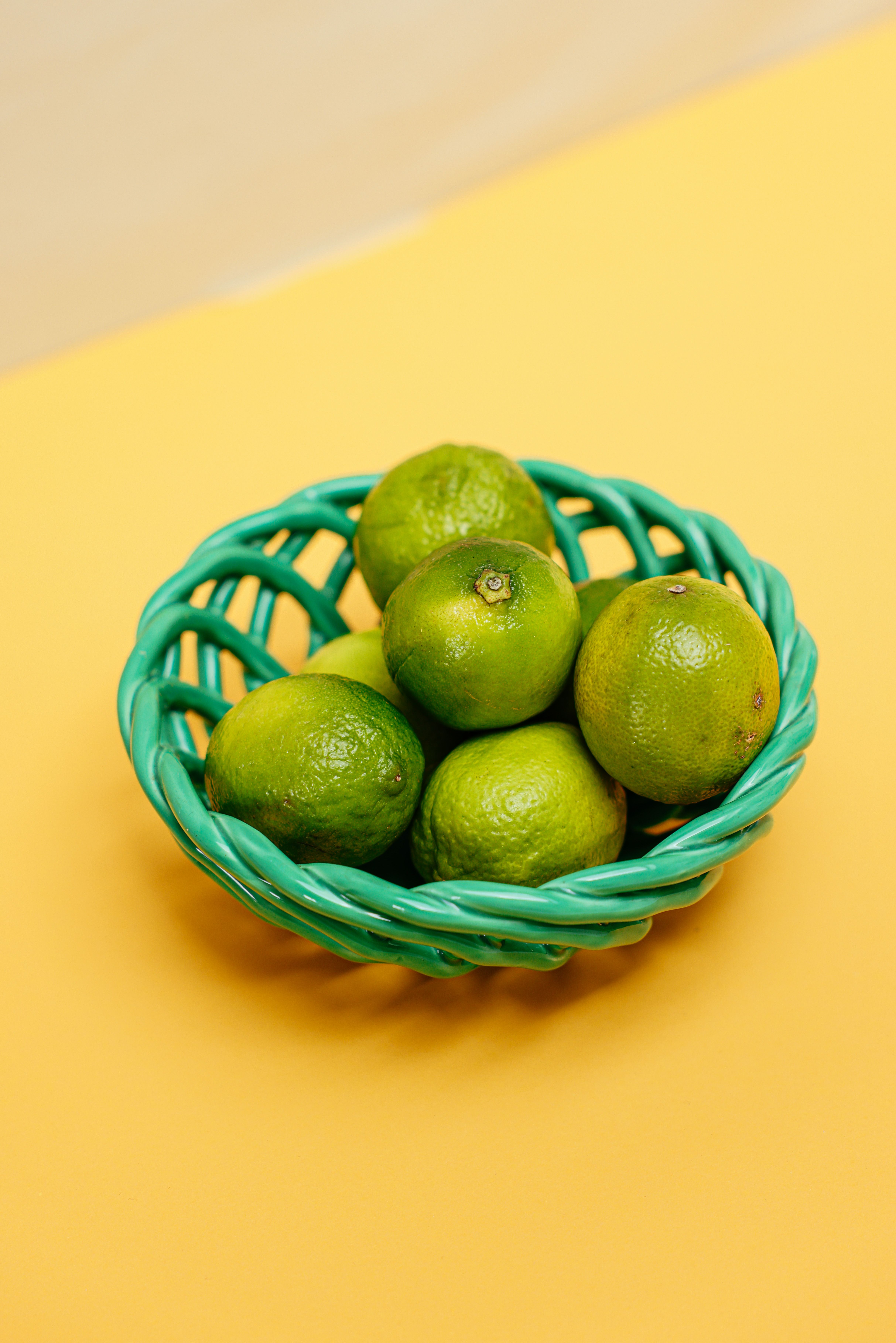 Limes on Green Round Basket · Free Stock Photo