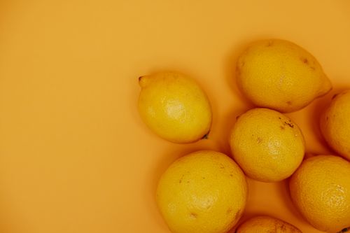 Free A close-up of fresh yellow lemons arranged on a matching vibrant background, exuding a citrusy feel. Stock Photo