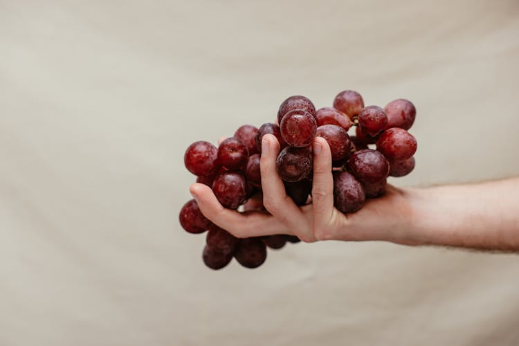 A Hand Holding Grapes Fruit