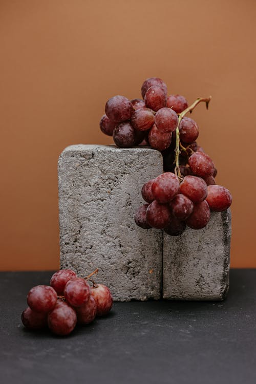 A Close-Up Shot of Grapes and Concrete Blocks