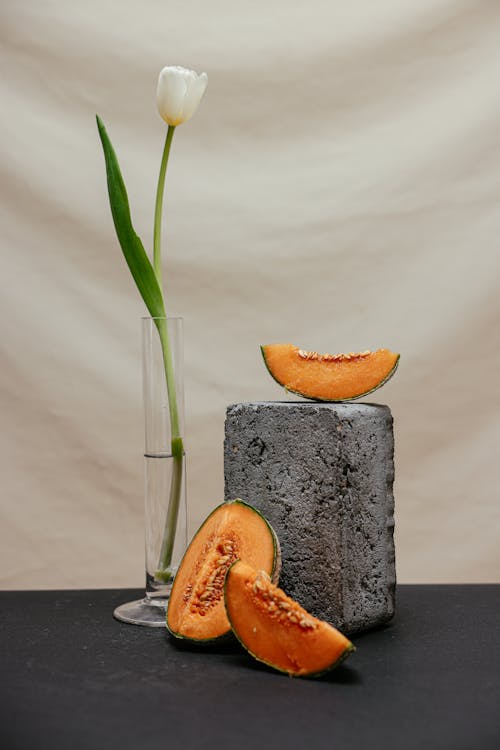 Slices of Melon Beside the Gray Concrete Block