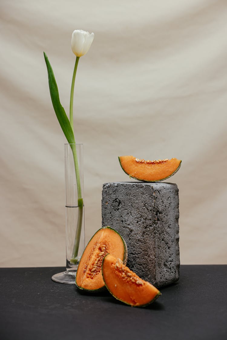 Slices Of Melon Beside The Gray Concrete Block