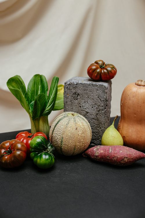 Free A vibrant display of fresh vegetables and fruits, including tomatoes, pumpkin, and more, arranged creatively. Stock Photo