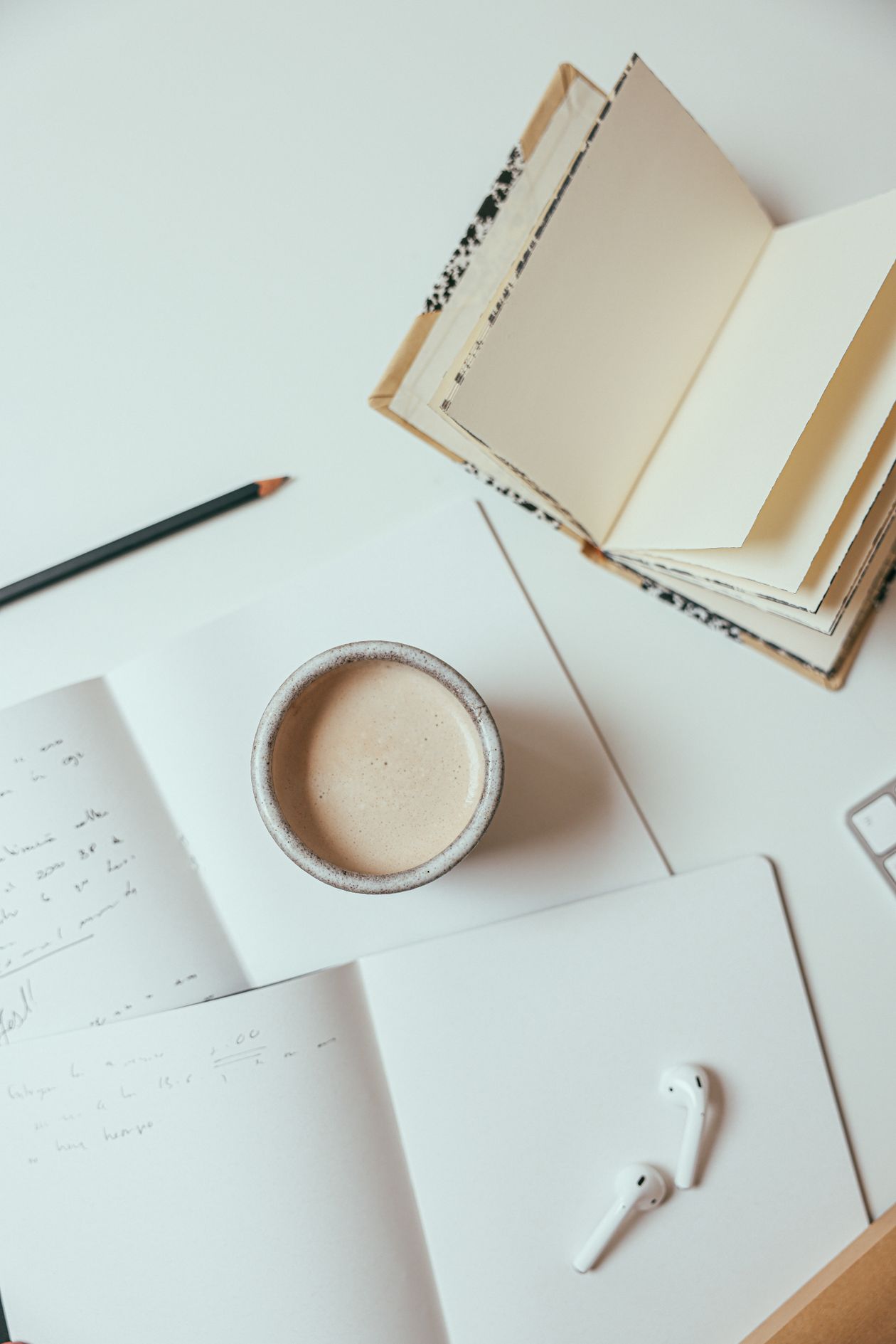 Overhead view of a cozy student workspace with coffee, notebooks, and stationery — student desk setup