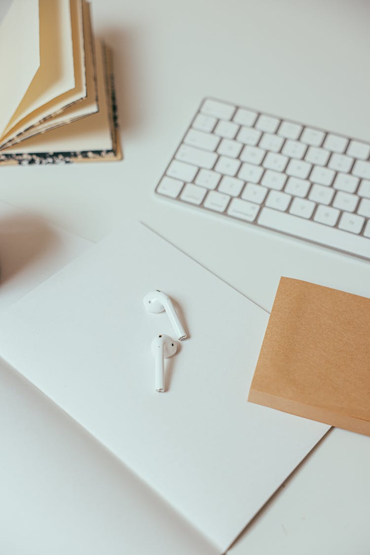 Wireless Headset And Wireless Keyboard On A White Surface