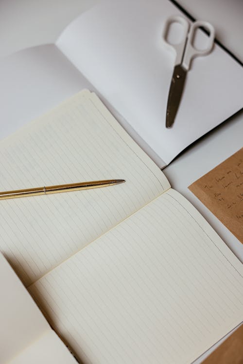 Open Notepads on a White Surface · Free Stock Photo