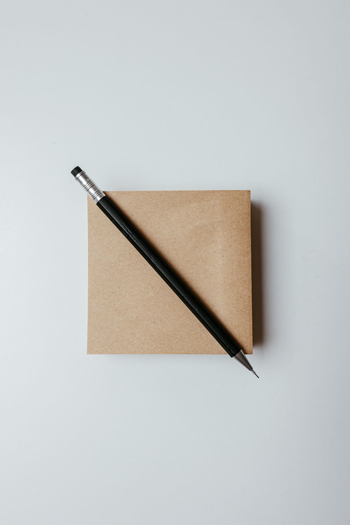 Bloc de notas con lápiz sobre fondo neutro