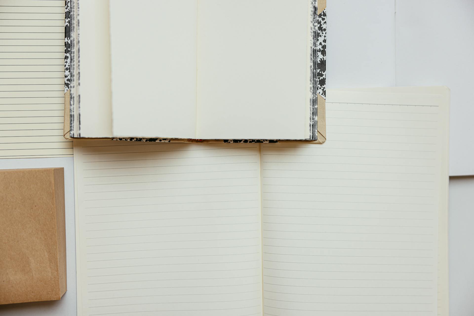 A variety of blank lined notebooks in a flat lay, perfect for writing and journaling inspiration.