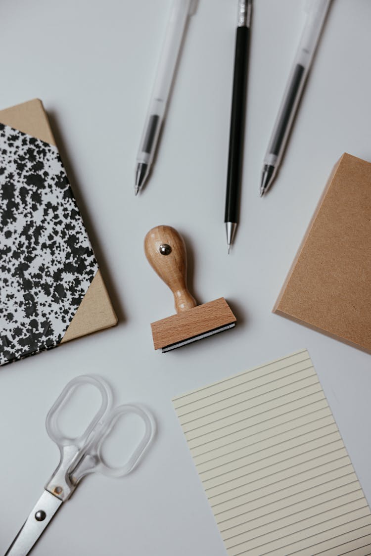 Pens And Paper On A White Surface