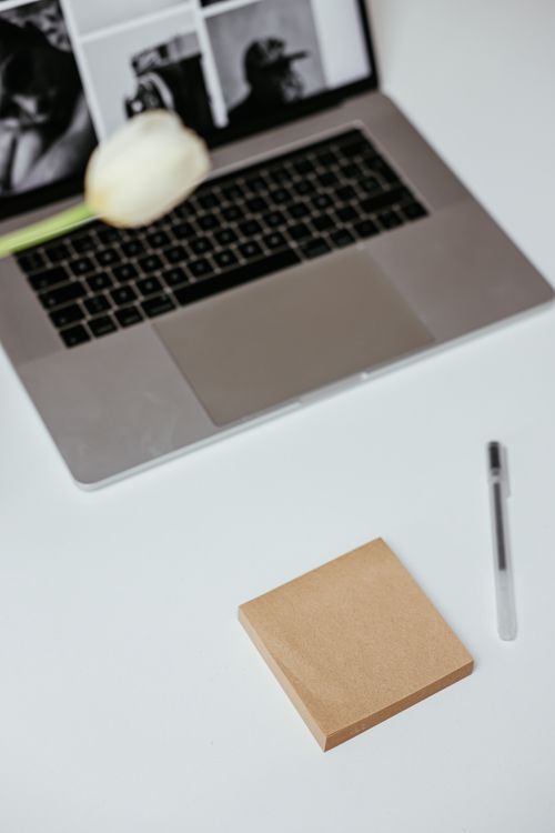 Free Stylish minimalist workspace featuring a laptop, pen, and sticky notes. Stock Photo