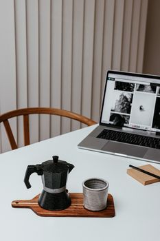 A serene minimalist workspace with a moka pot and laptop, perfect for remote work inspiration.