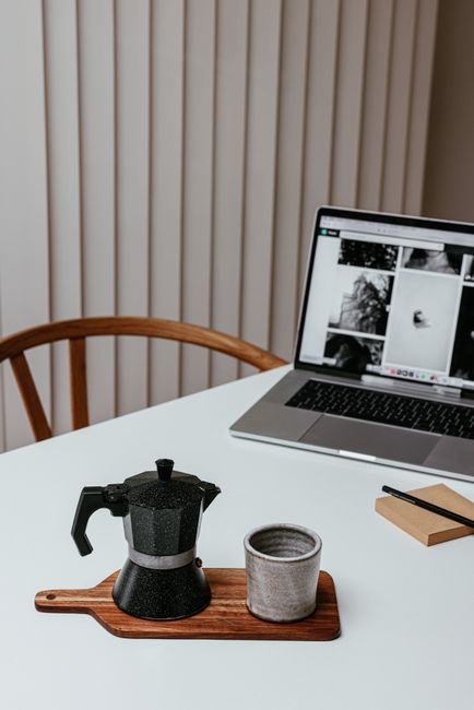A serene minimalist workspace with a moka pot and laptop, perfect for remote work inspiration.