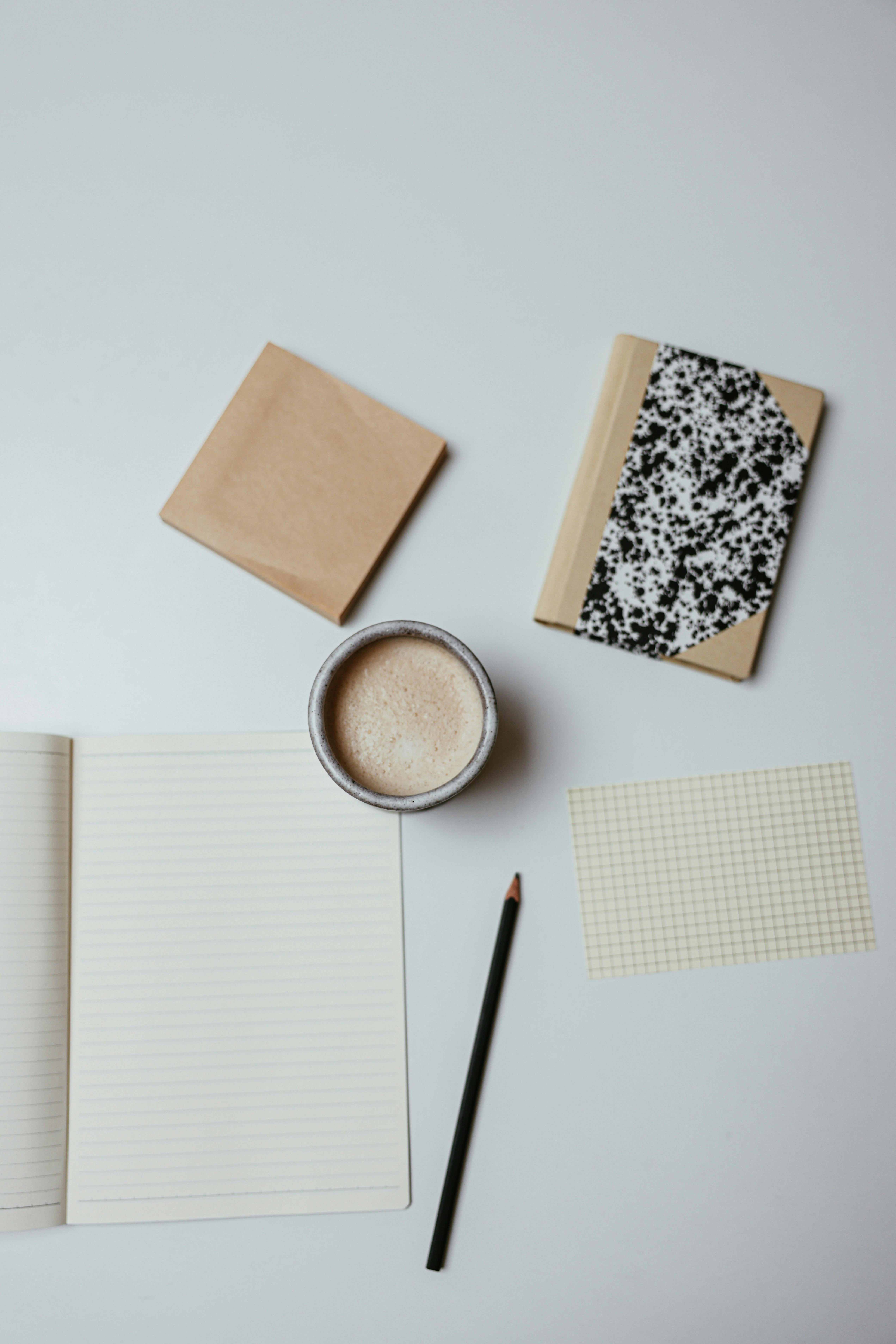 black pen on white paper beside brown paper