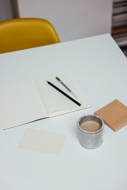Free Minimalistic workspace setup with a notebook, pencils, and a cup of coffee. Stock Photo