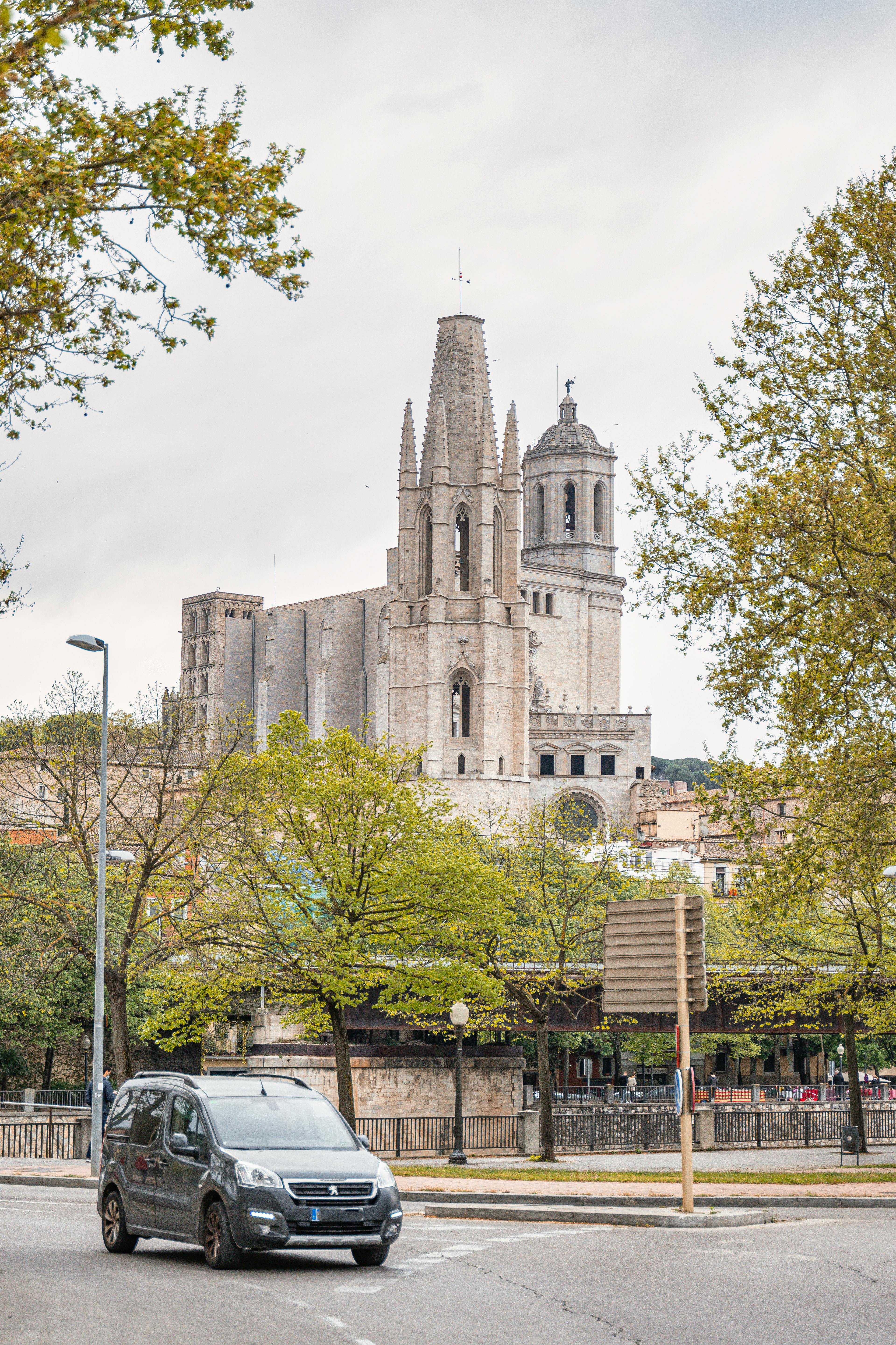 car on the street with the cathedral of saint mary of girona in the background girona spain